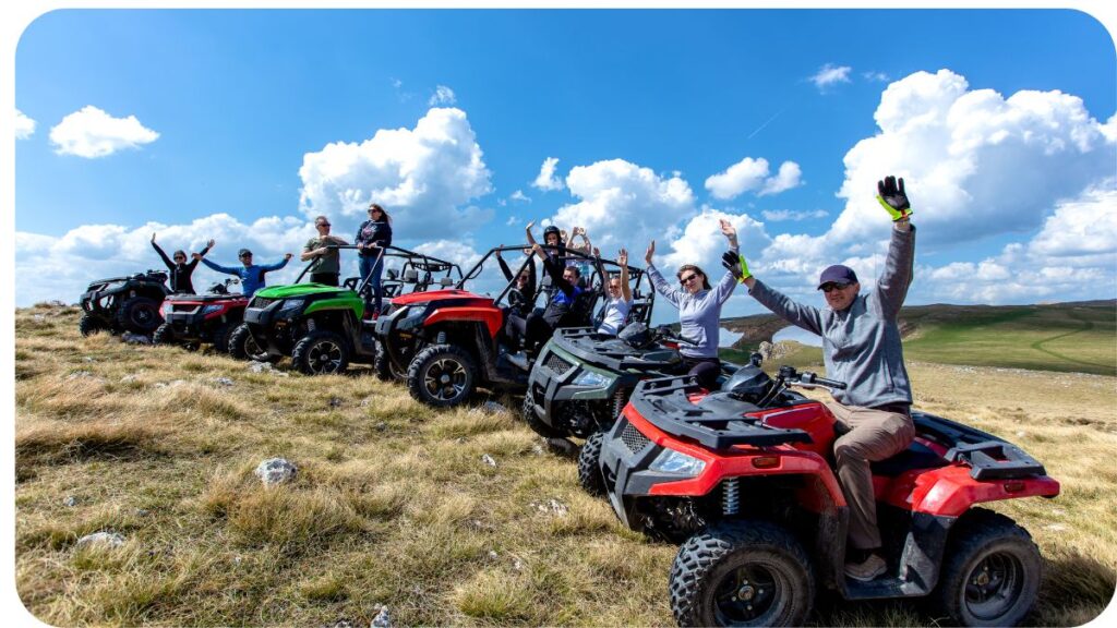 a group of people riding ATVs in the mountains.