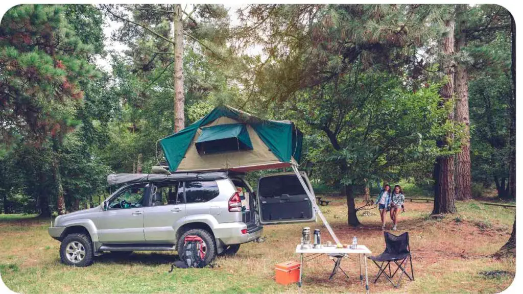 an suv with a tent on top of it in the woods