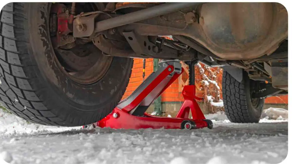 a red jack under a car in the snow